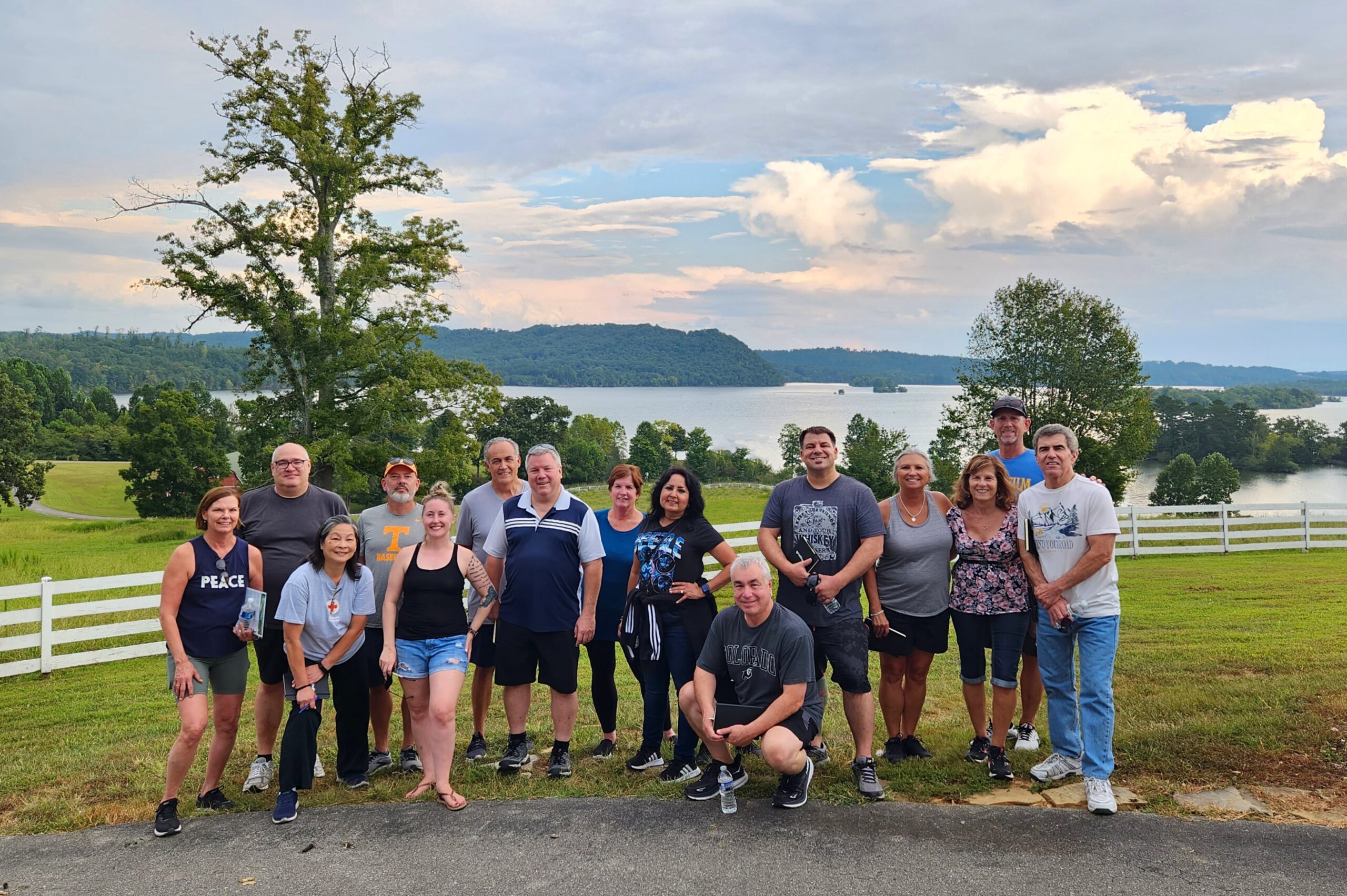 LBMB INC Team Photo - Several people lined up for a team photo in front of a majestic lake and skyline